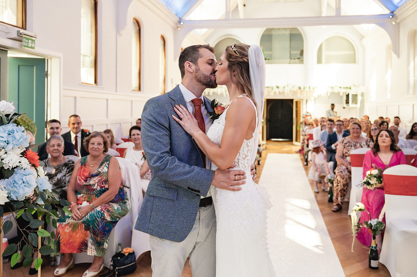 Natalie and George kissing during the wedding ceremony at Ashburton Hall