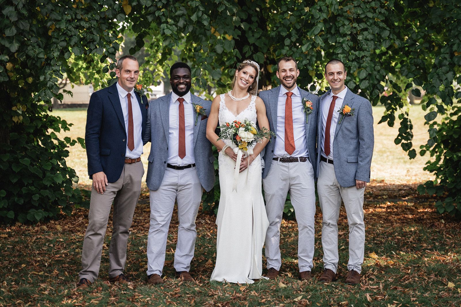 Portrait of Natalie and George with the groom's men at Ashburton Hall