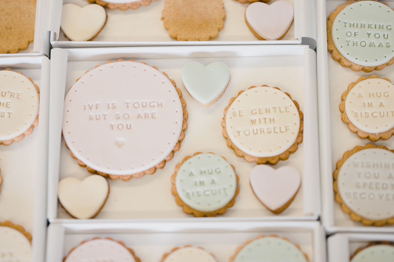 personalised iced biscuits with messages of support in pastel colours