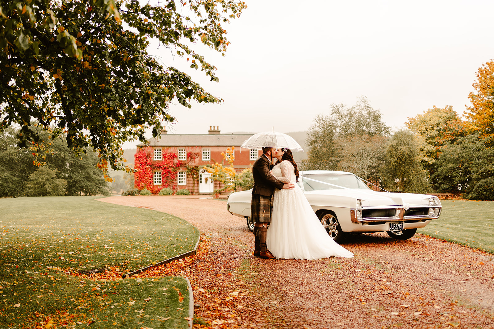 bride and groom kiss in front of ballogie house during autumn wedding