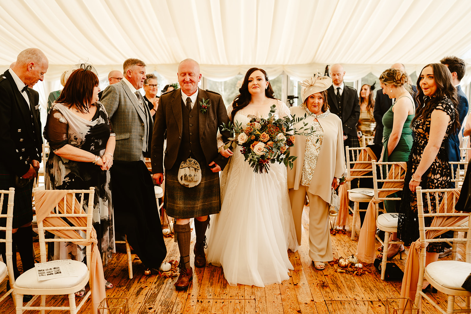 bride and her two parents walks down the aisle at ballogie house wedding ceremony