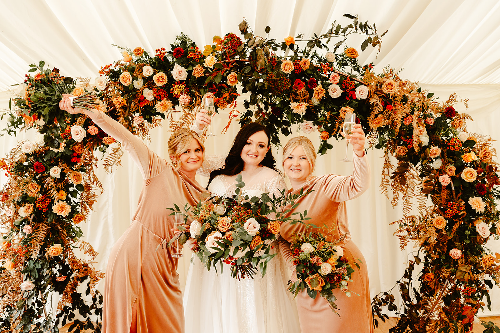 bride strikes a fun pose with her bridesmaids at ballogie house scottish wedding
