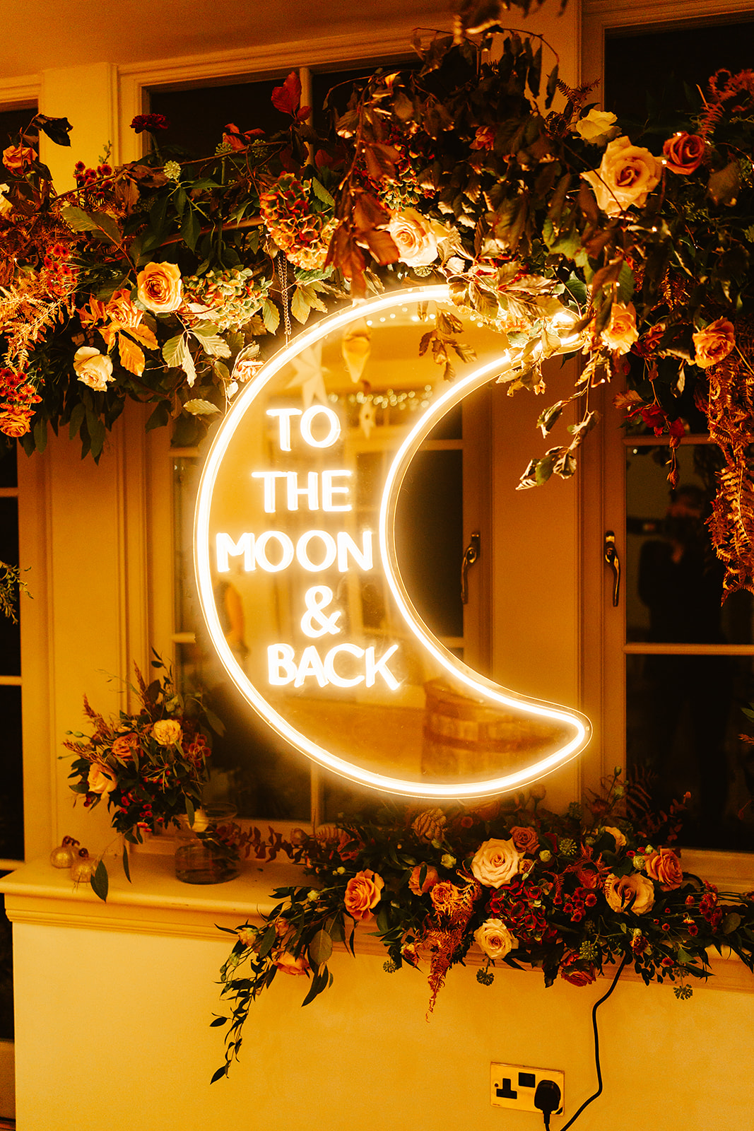 bespoke neon sign of a monn it says to the moon and back