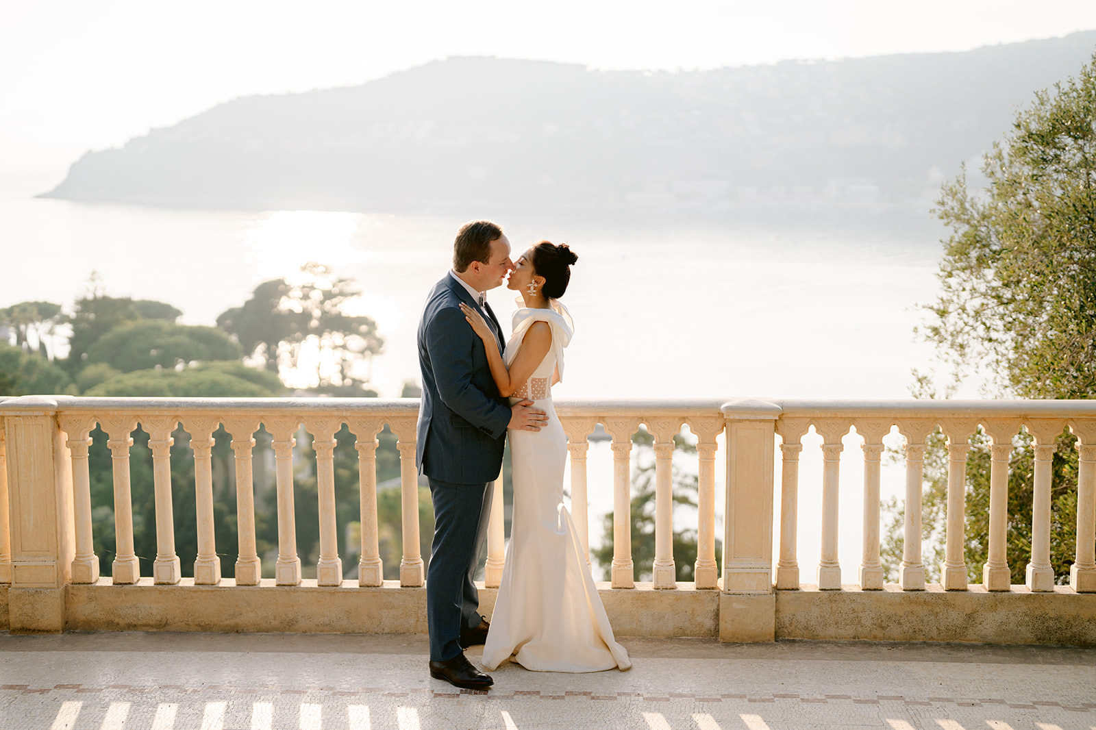 bride and groom kissing with the sea in the background at villa ephrussi de rothschild