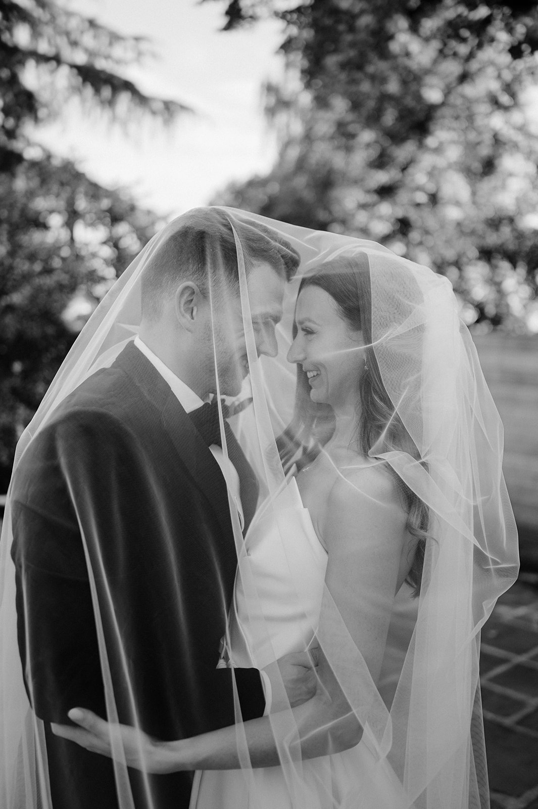 bride and groom under veil at barns and yard wedding venue