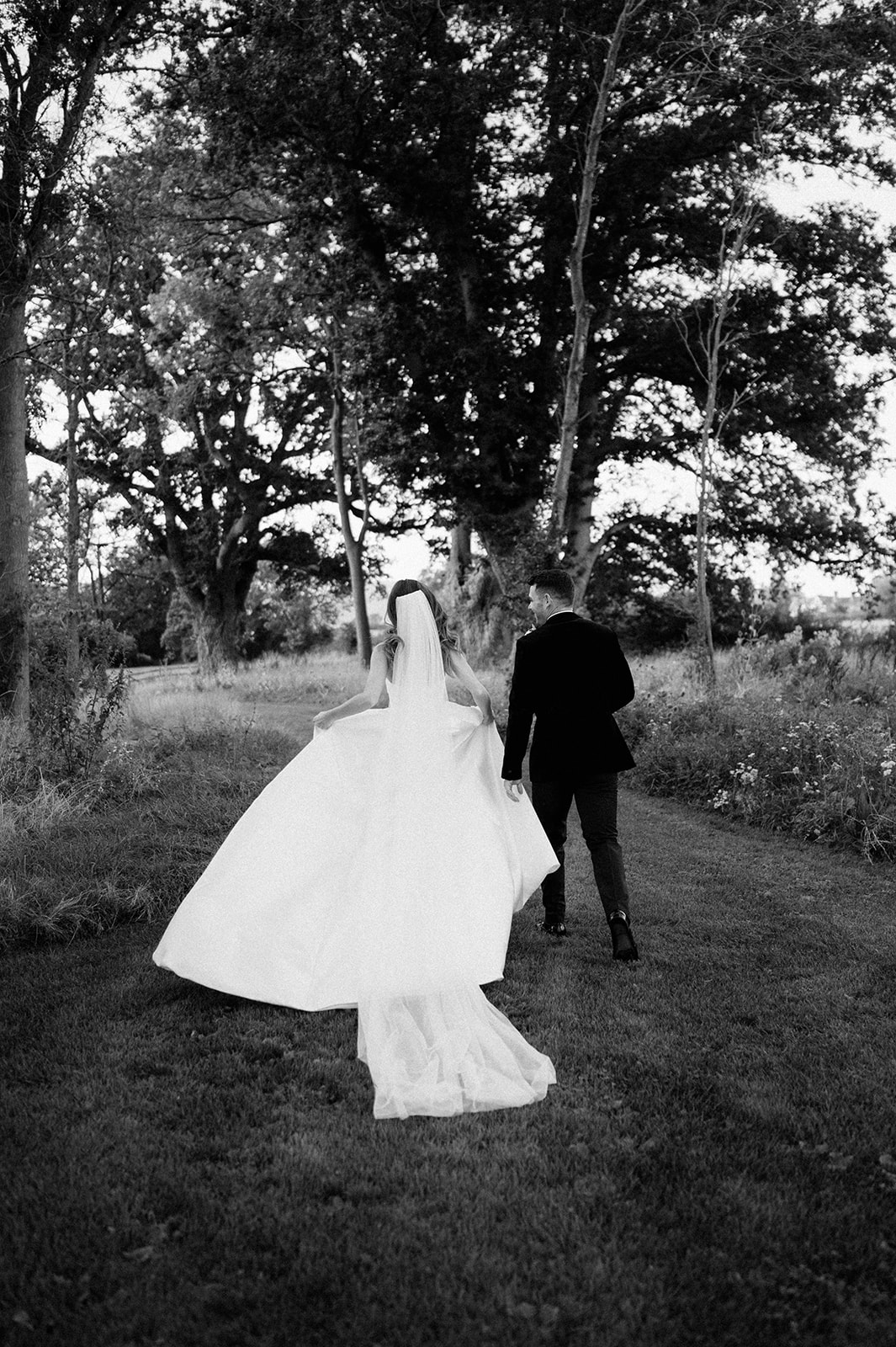 bride and groom walking at barns and yard wedding venue