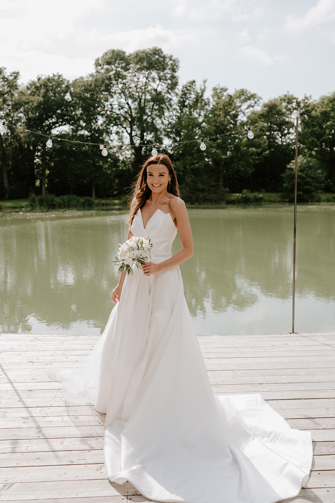 bride standing in front of lake at barns and yard wedding venue