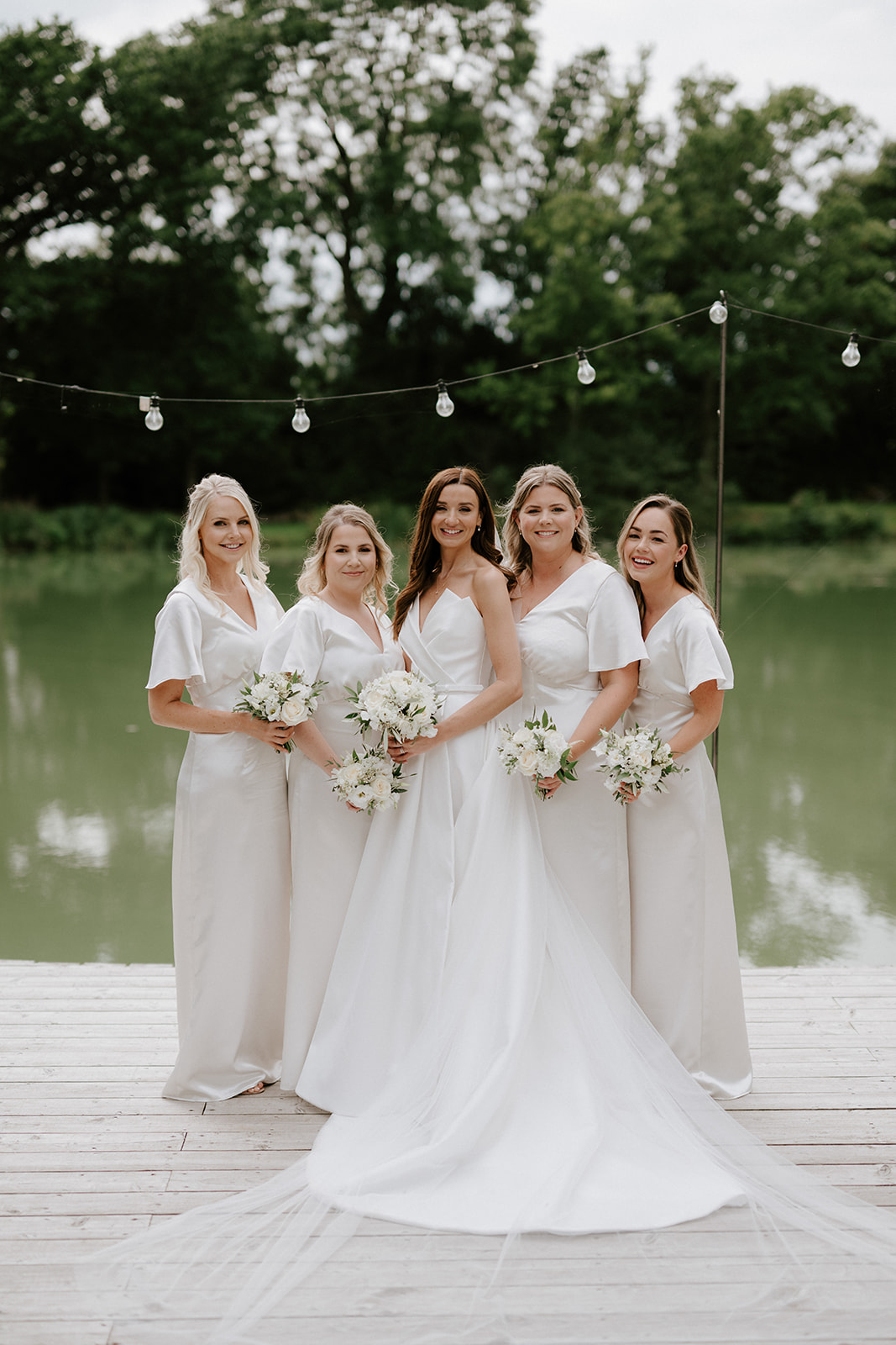 bridesmaids in front of lake at barns and yard wedding venue