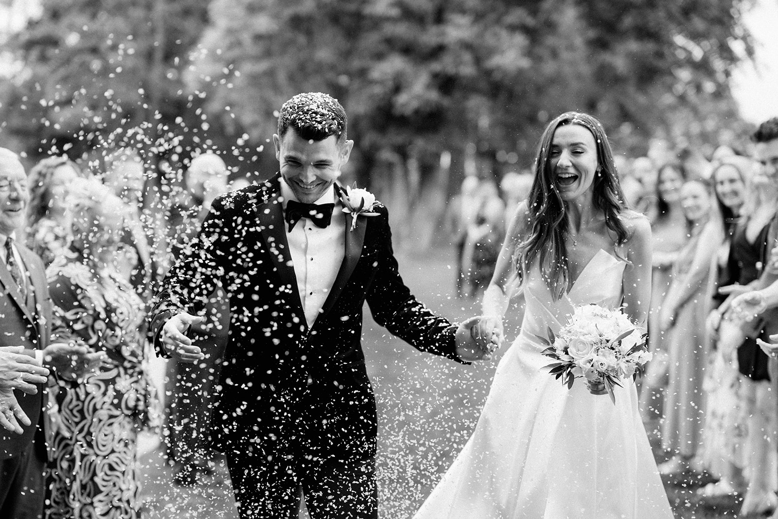 couple walking through confetti line at barns and yard wedding venue