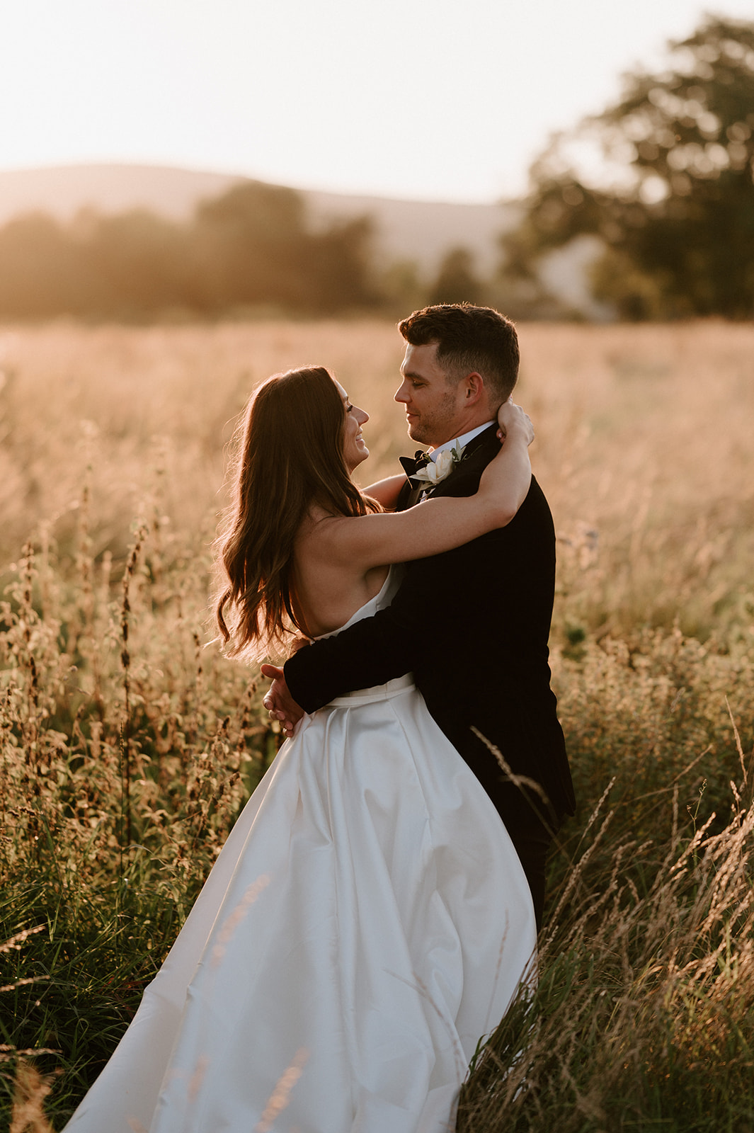 groom and bride in field with malvern hills at sunset at barns and yard 