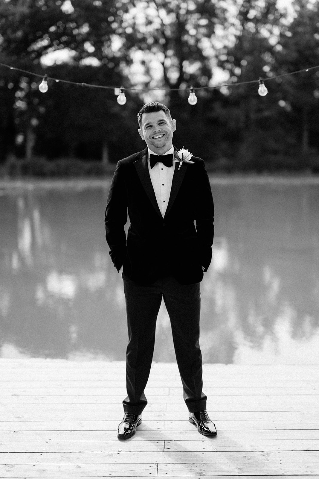 groom standing in front of lake at barns and yard wedding venue