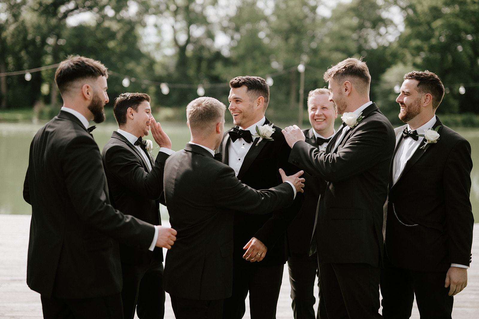 groomsmen in front of lake at barns and yard wedding venue