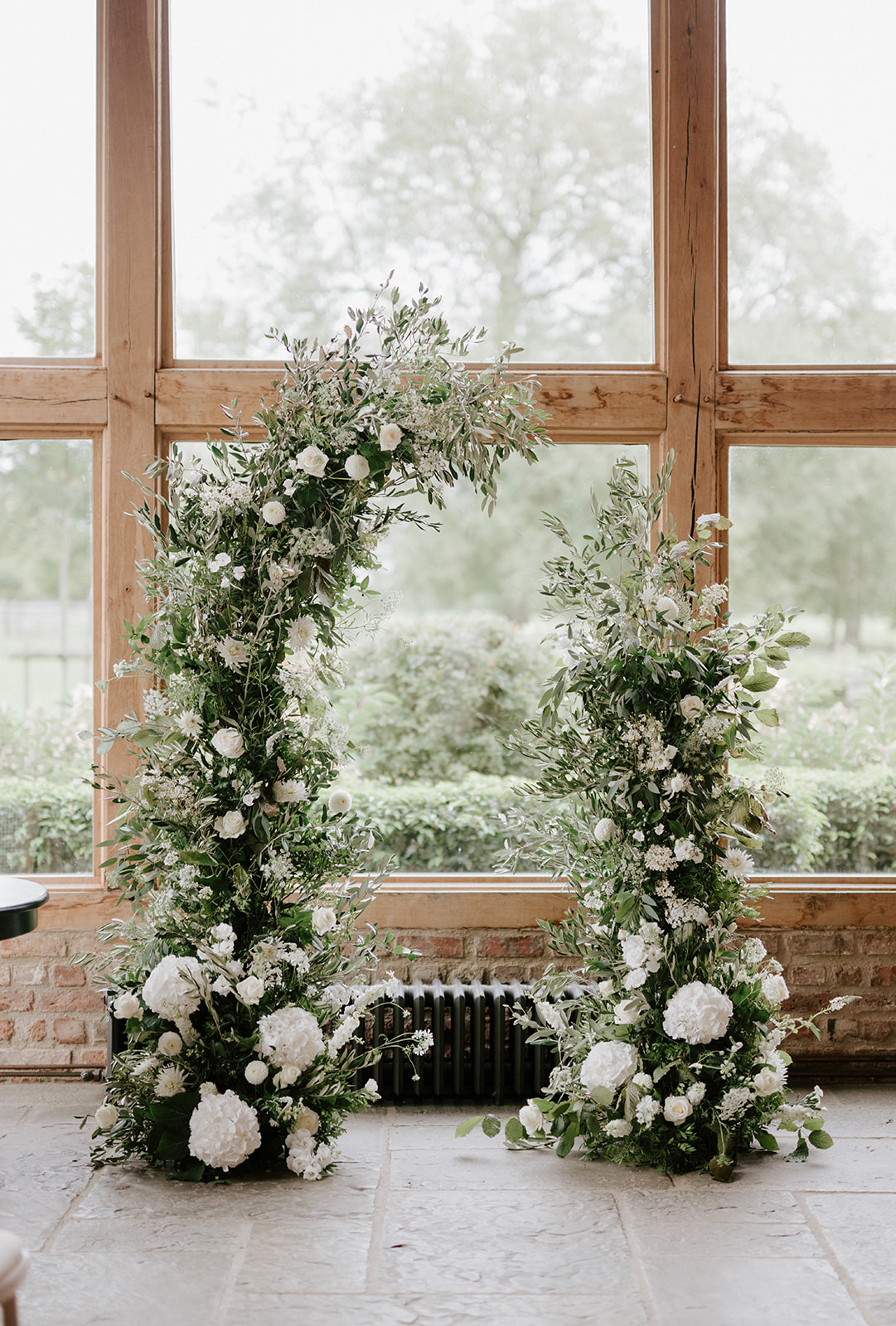 neutral floral wedding arch ceremony backdrop at barns and yard wedding venue