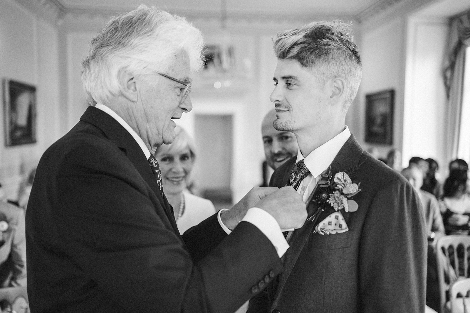 father of the groom fixing tie 