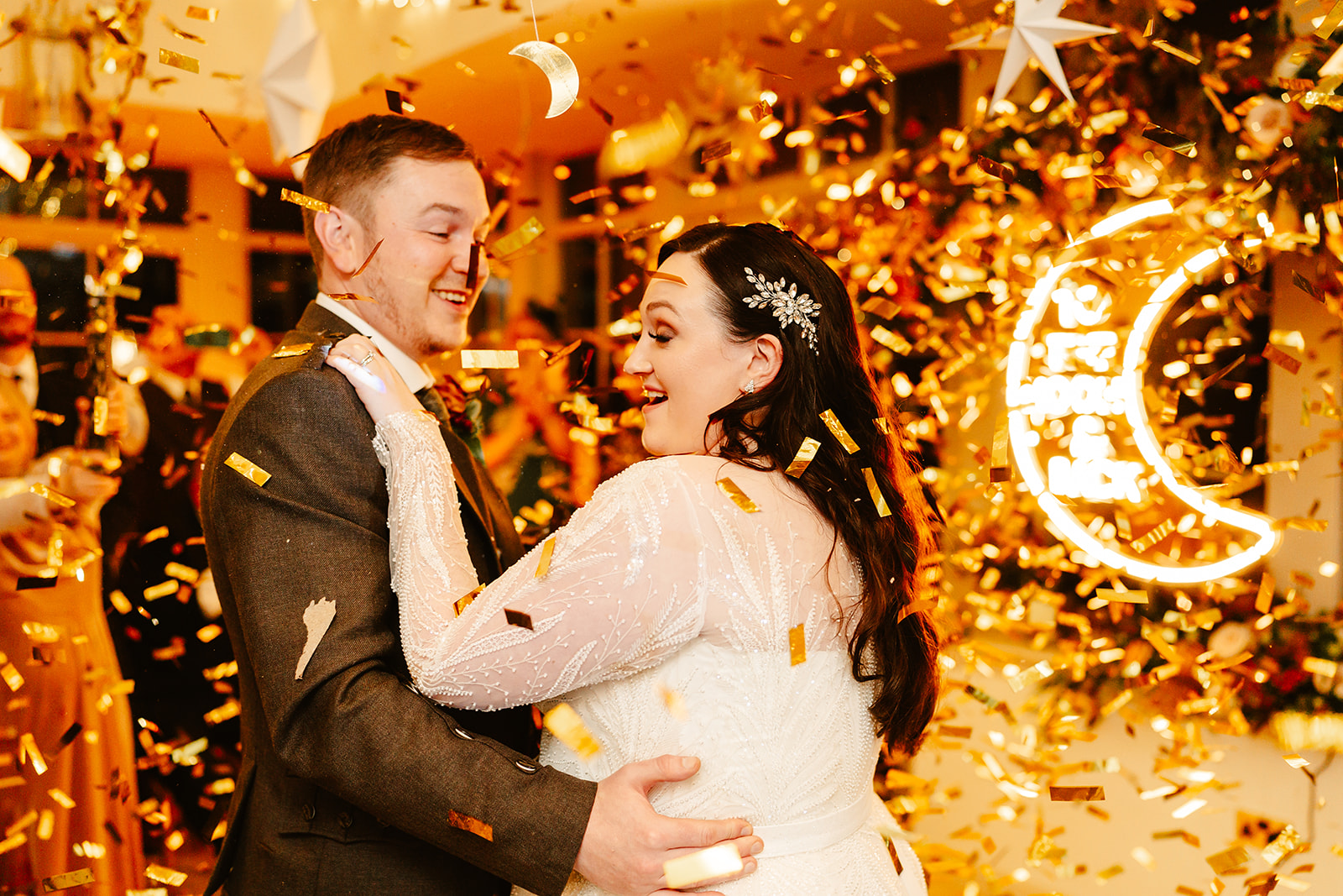 couple hold one another while gold confetti falls on them during their first dance at Ballogie House wedding