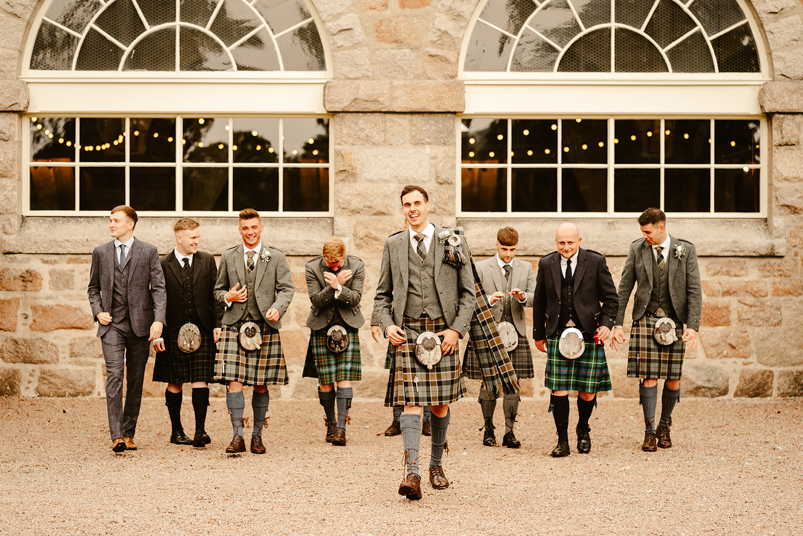 groom and groomsmen pose by walking towards the camera infant of coos cathedral wedding venue