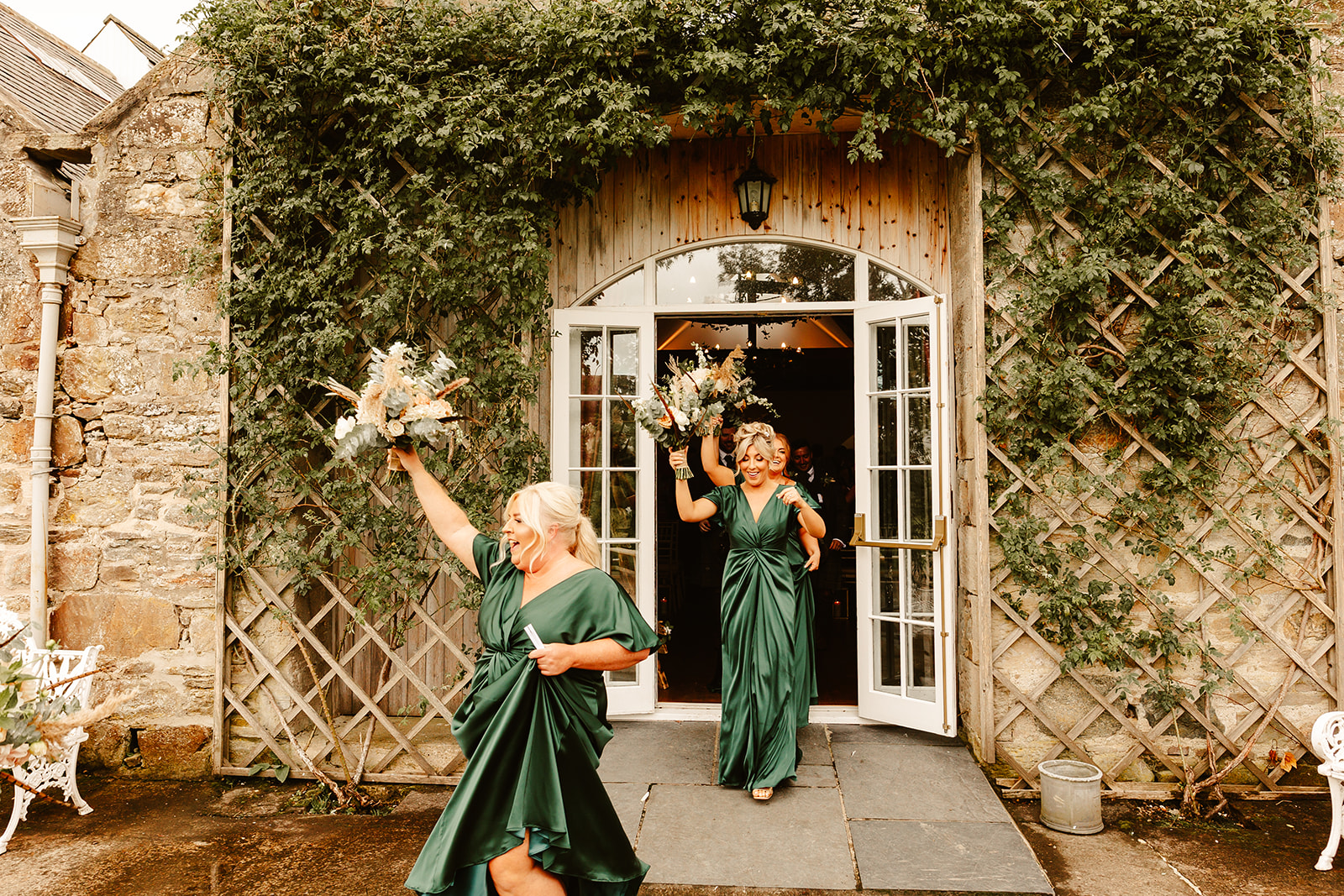 bridesmaids celebrant walking out of Aswanley wedding venue by holding their flowers in the air