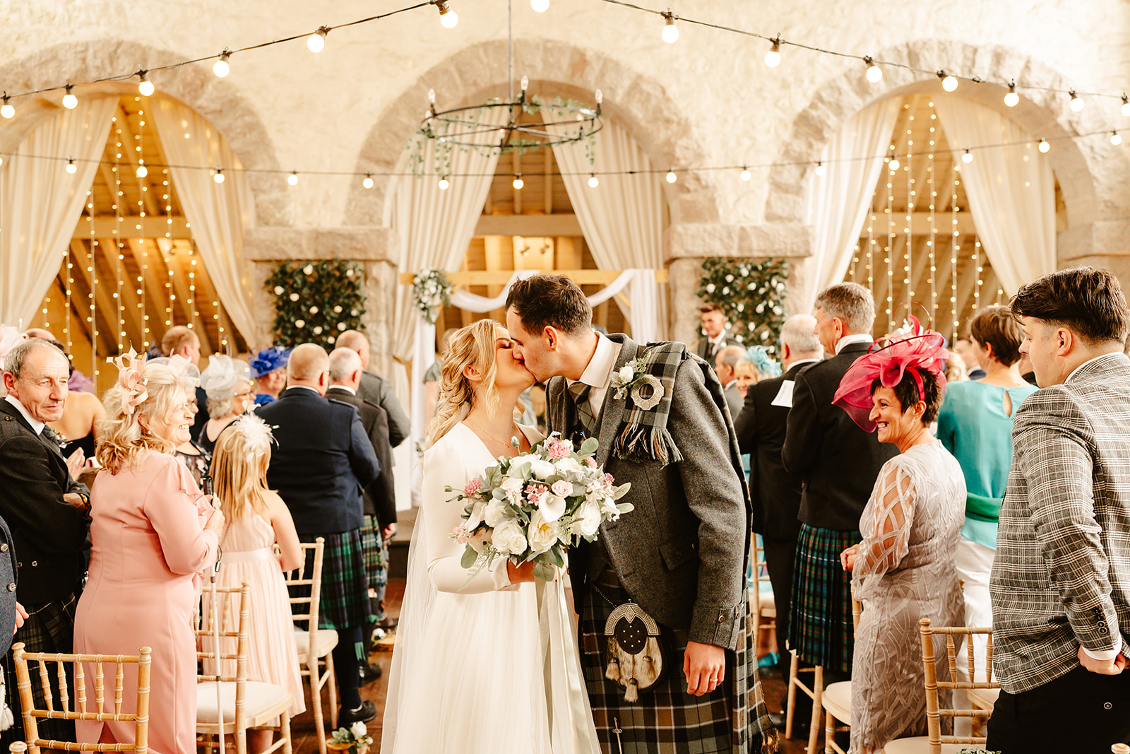 couple kiss at the end of the aisle at the coos cathedral wedding venue