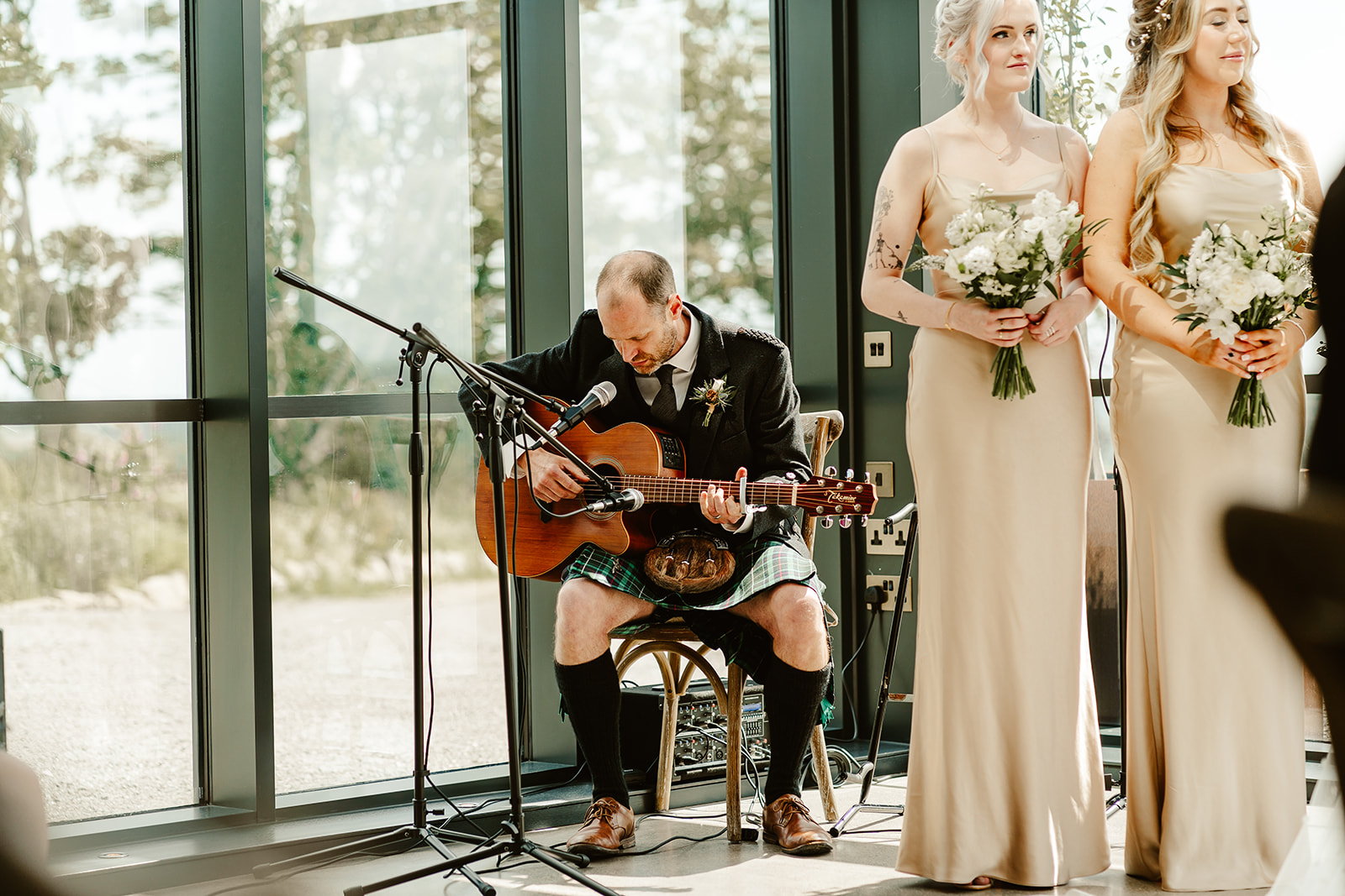 a man wearing a kilt is playing guitar during a wedding ceremony at Schivas Steading