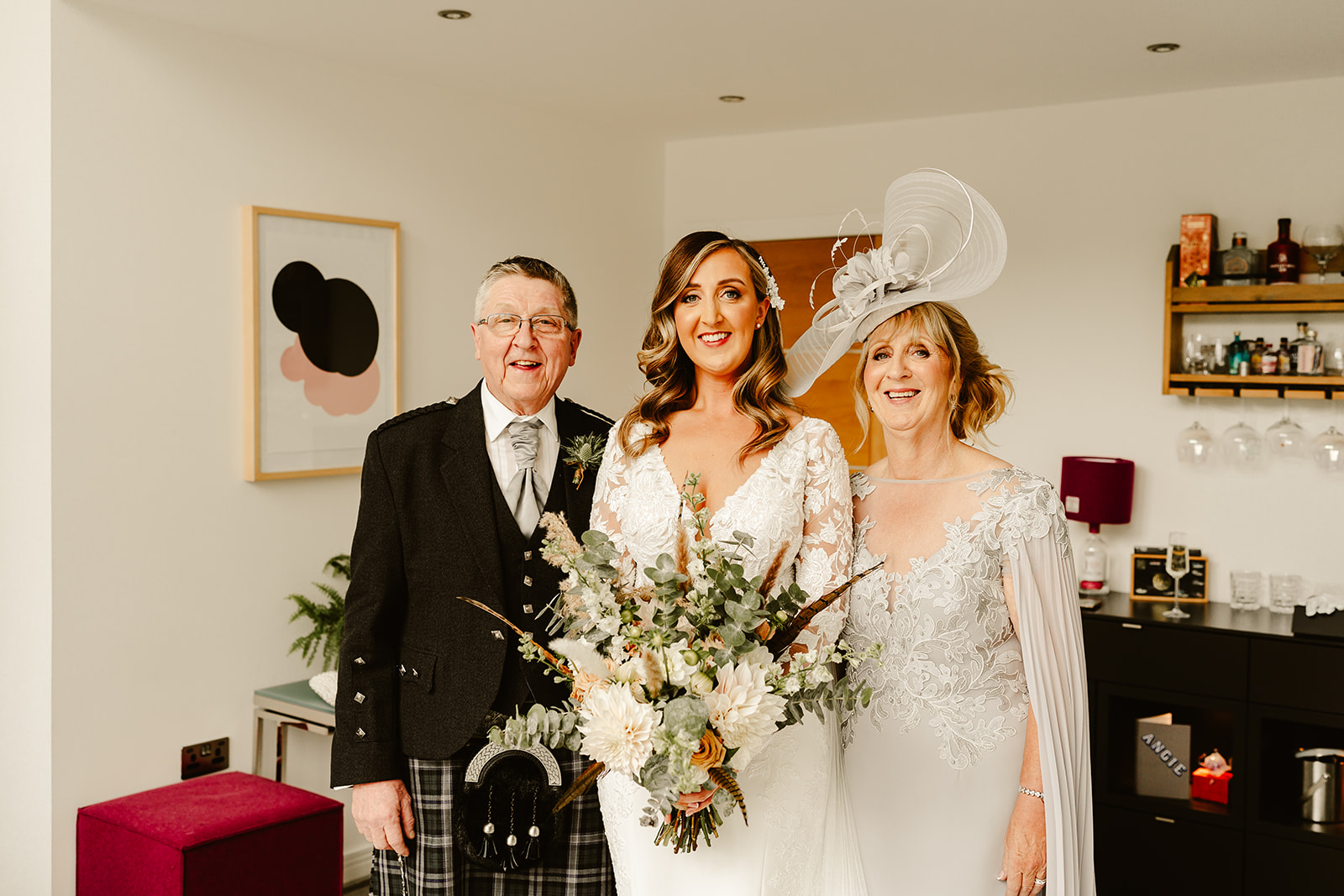 a bride stands with her mother and father on the morning of her Aswanley wedding