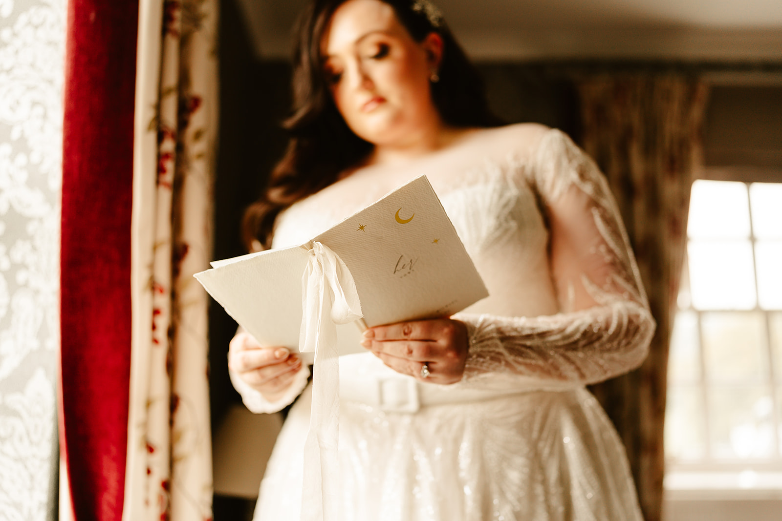 bride reads her vows by window light on the morning of her aberdeen wedding at Ballogie House