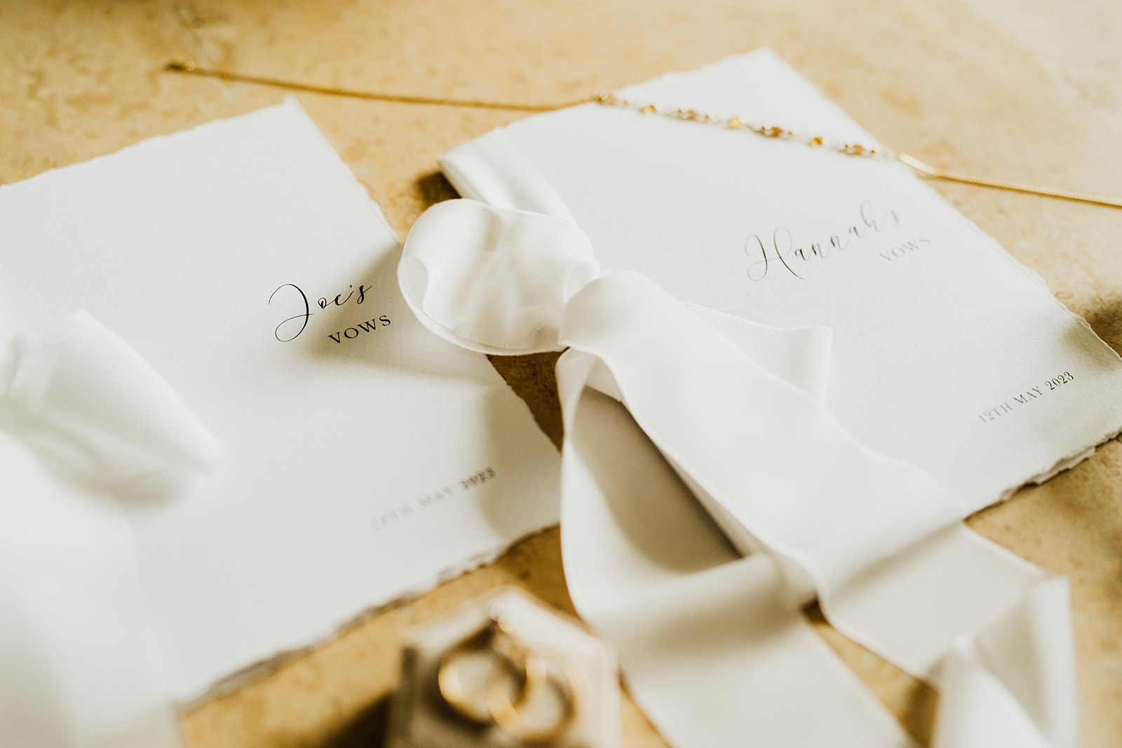 vow cards laying on table with other details like a necklace and ribbon