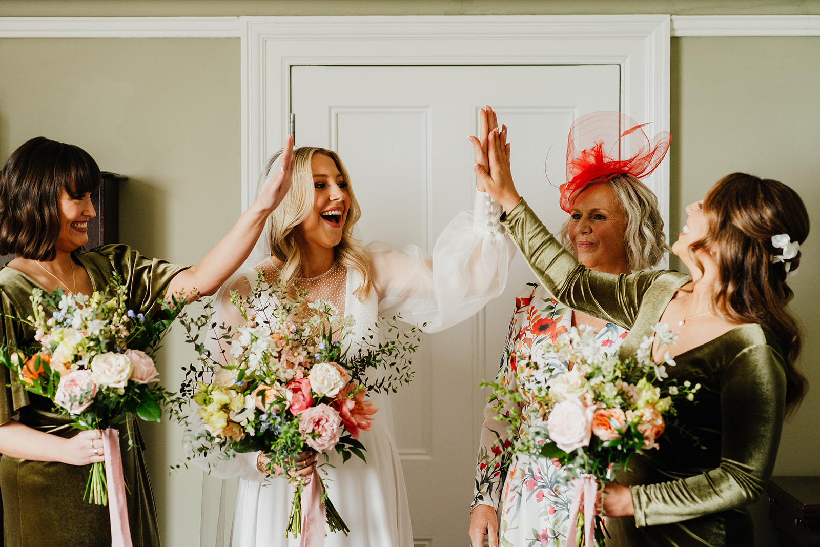 bride high fives her bridesmaids before her Scottish wedding ceremony