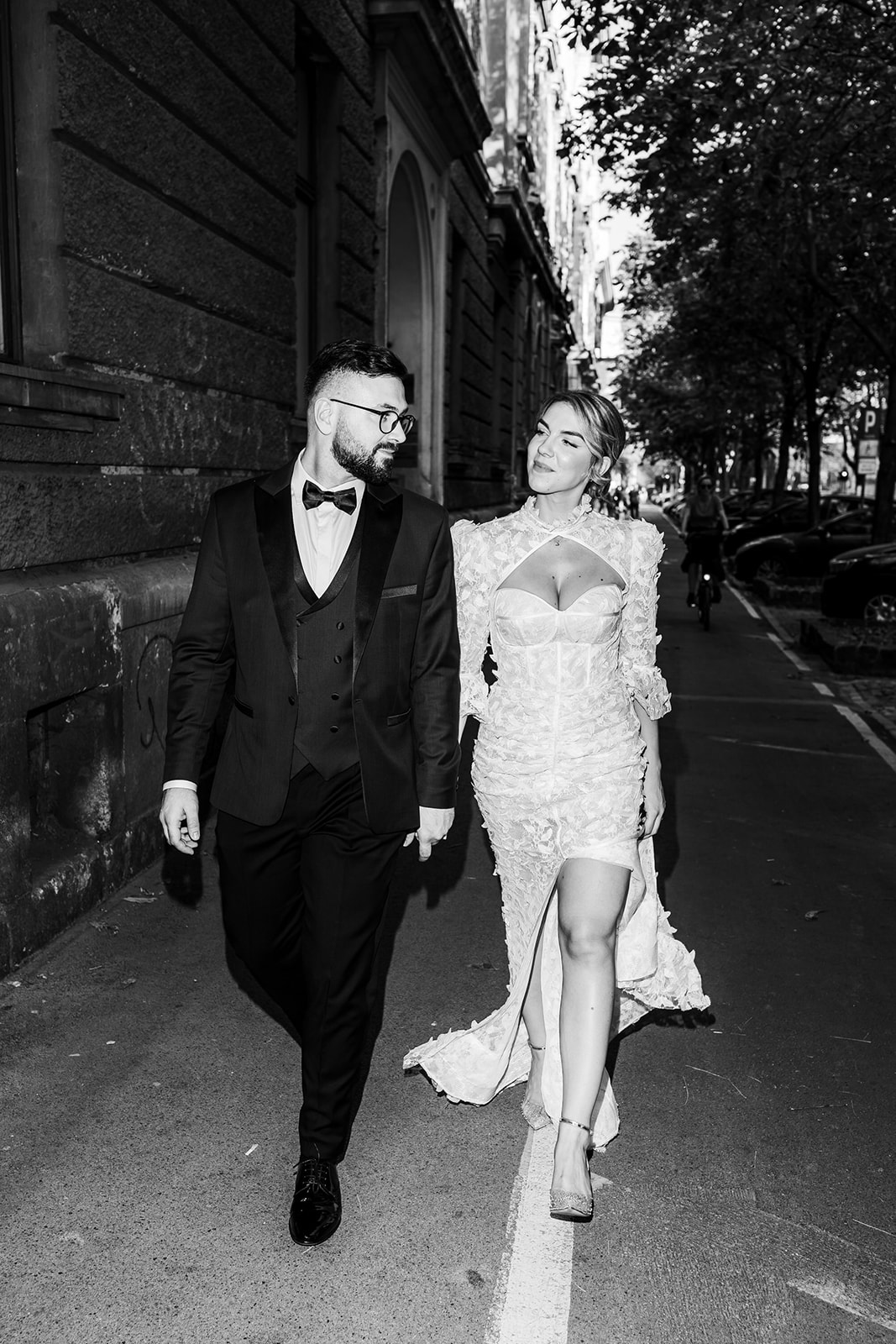 Stylish bride and groom walking through trendy Zagreb streets on their wedding day.