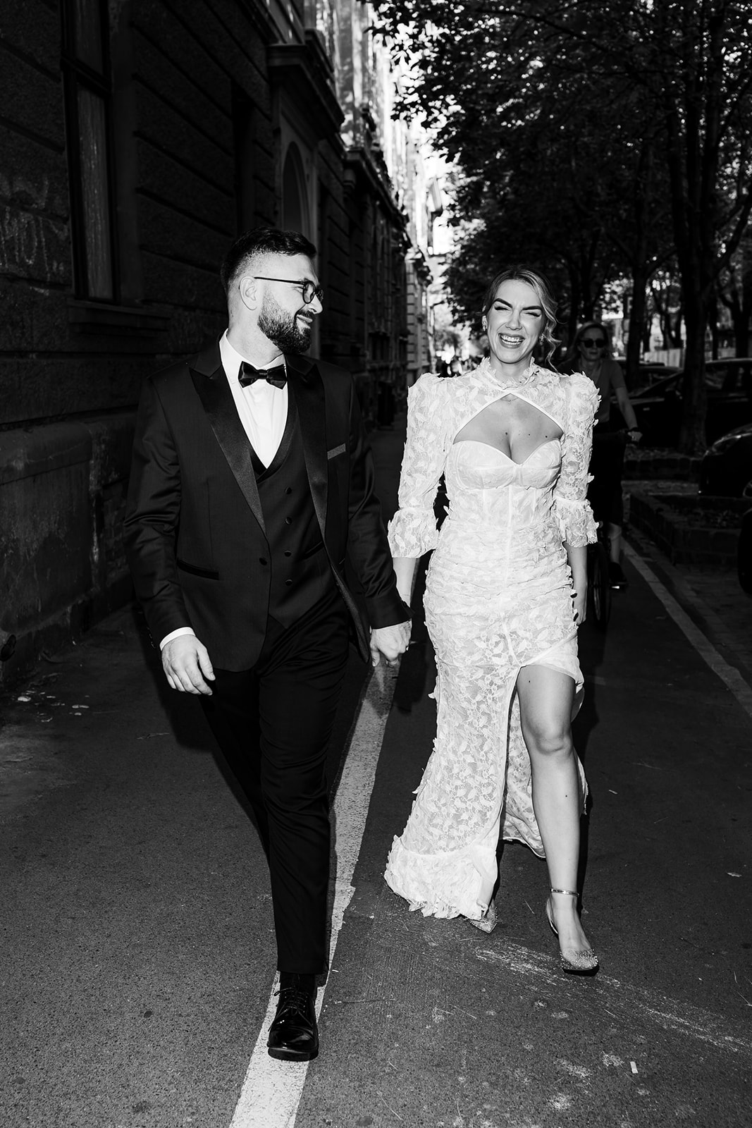 Stylish bride and groom walking through trendy Zagreb streets on their wedding day.