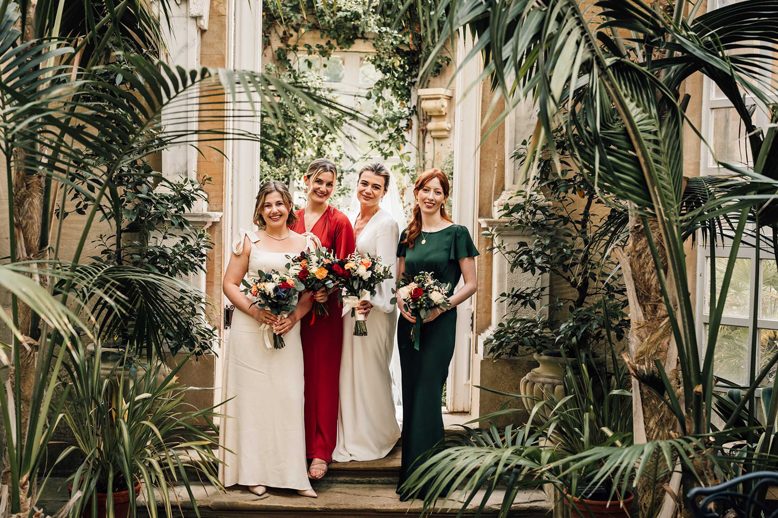 bridesmaids posing for a photograph in the conservatory at Harlaxton Manor