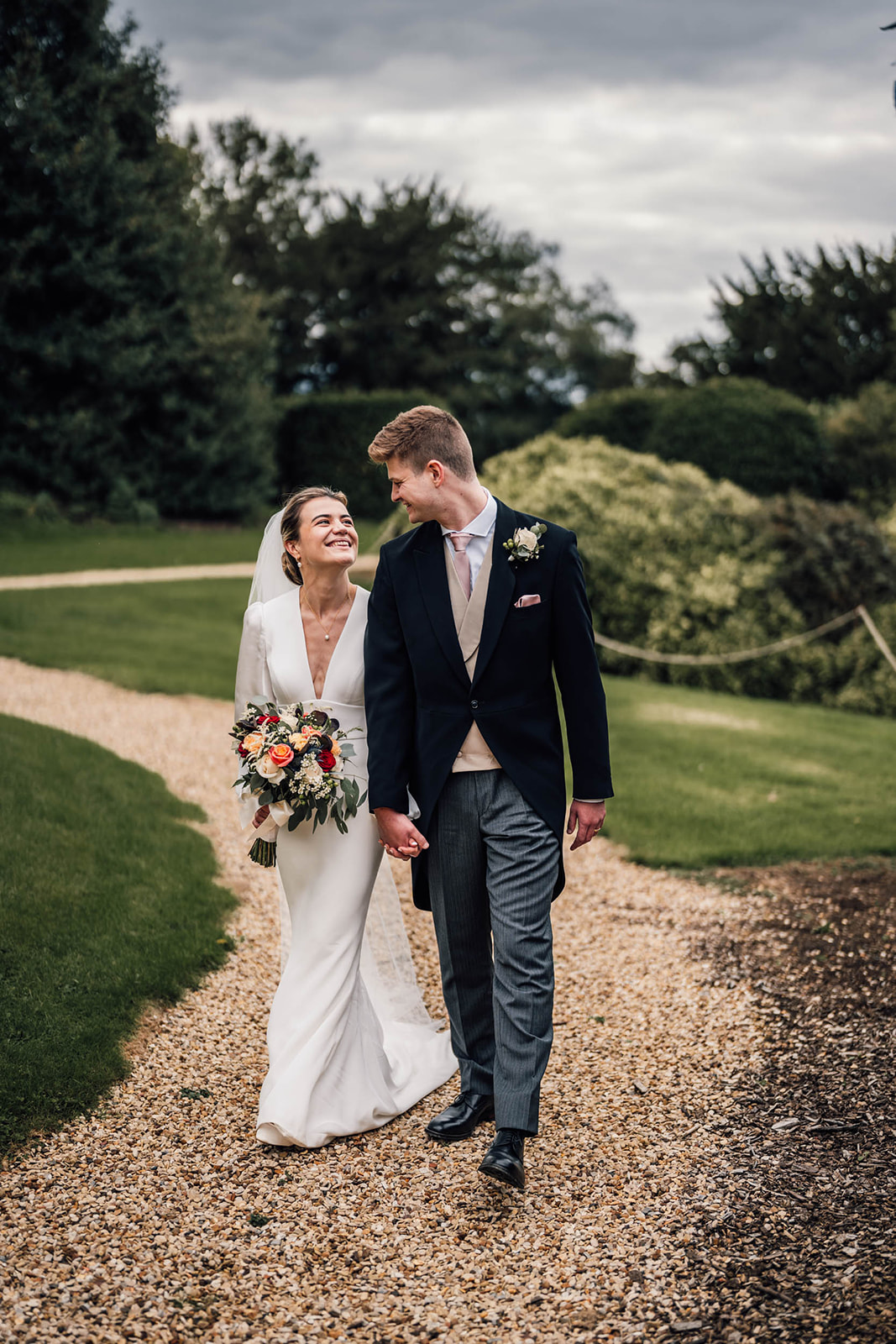 bride and groom walking in the gardens at Harlaxton Manor