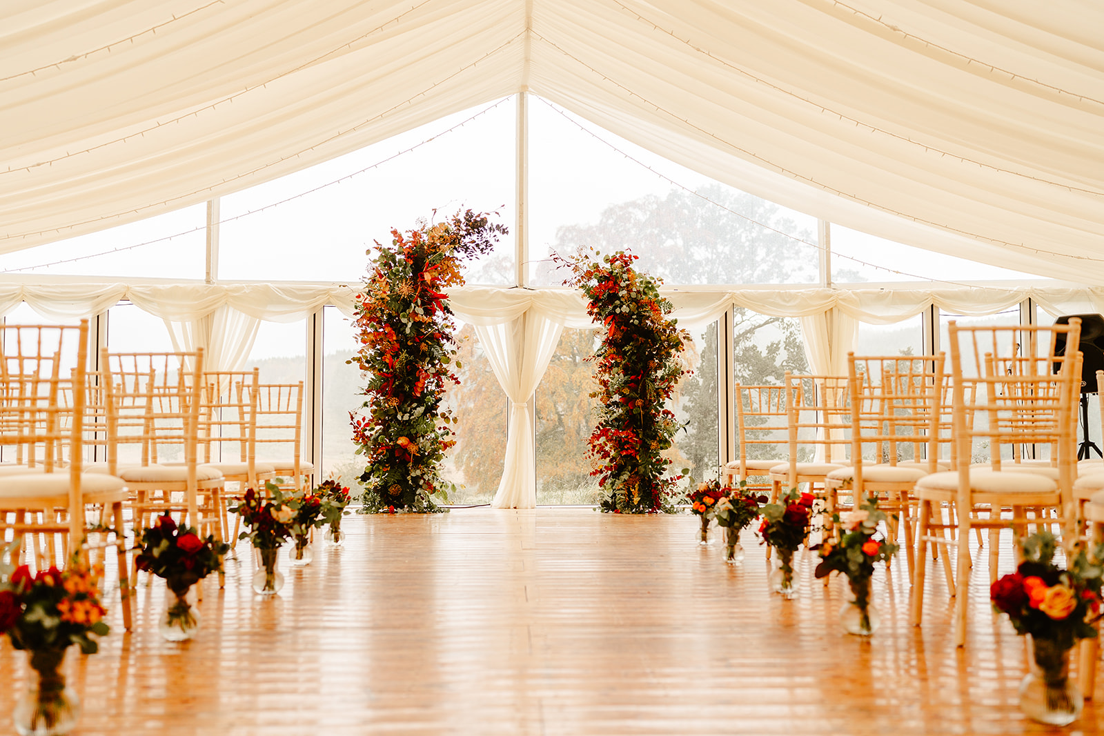 ceremony set up in marquee at ballogie house autumn floral arch