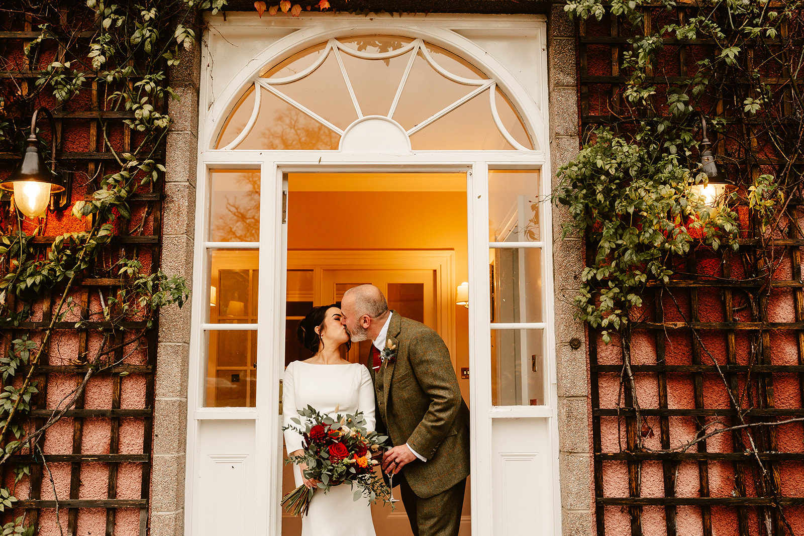 bride and groom kiss in the doorway of Ballogie House
