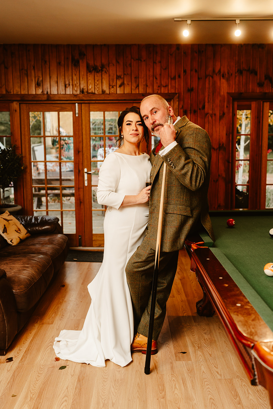 Bride and groom pose at pool table at Ballogie House