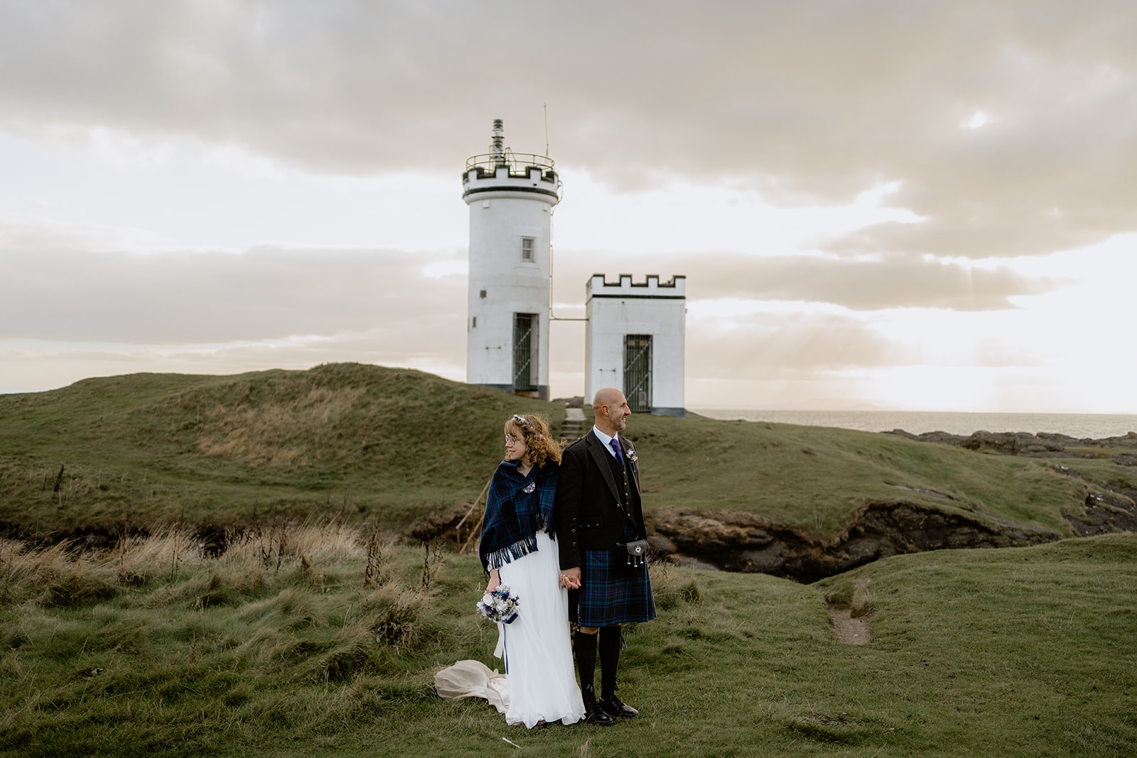 Bride and Groom stand in front of Lighthouse at Lady's Tower