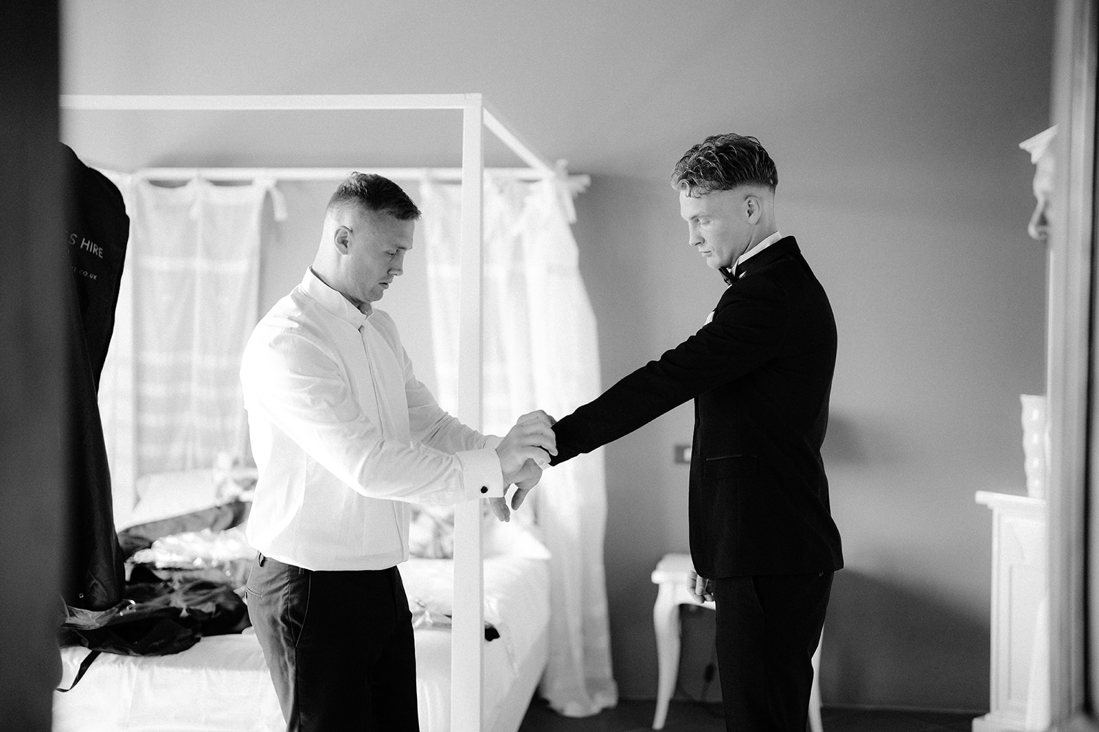 The best man is fixing the groom's cuffs