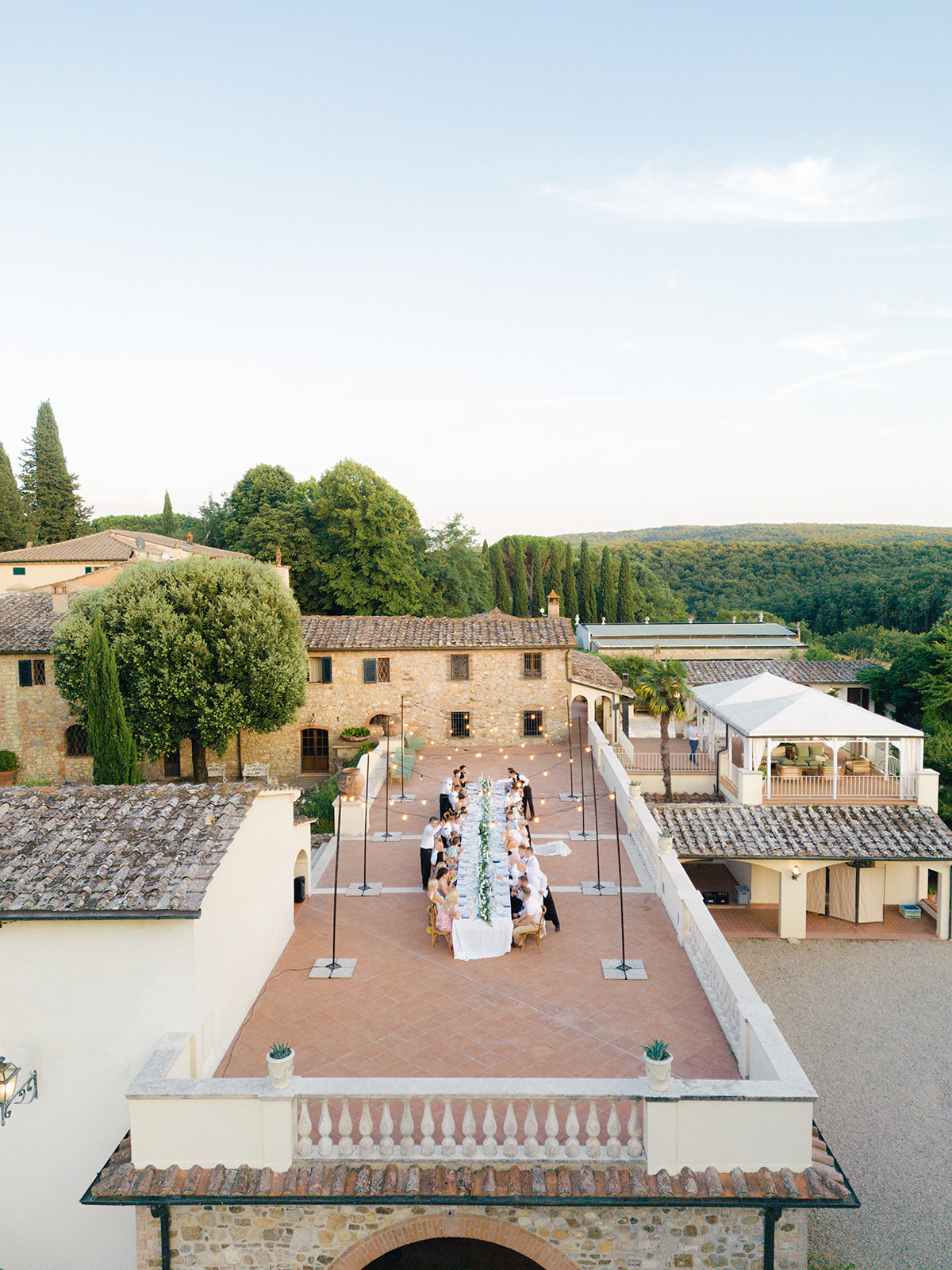 The bride and groom, along with their guests, dine at the imperial table on the terrace of Villa La Selva Wine Resort