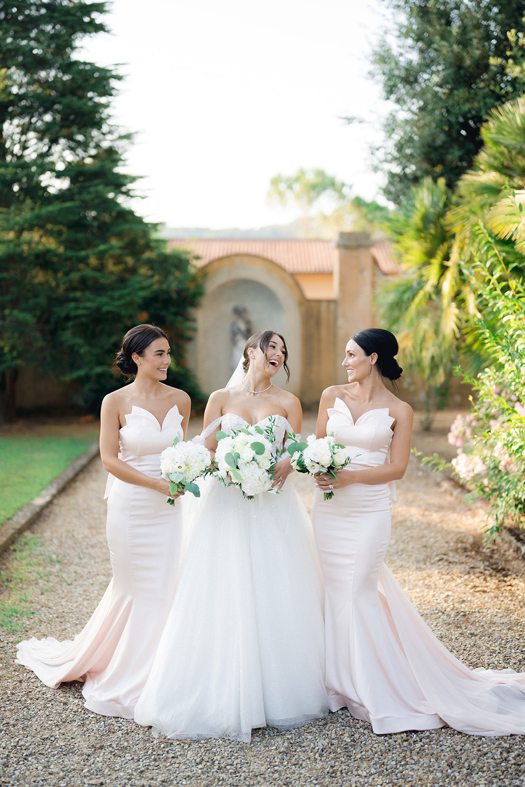 the bride and her sisters while posing for a group photo