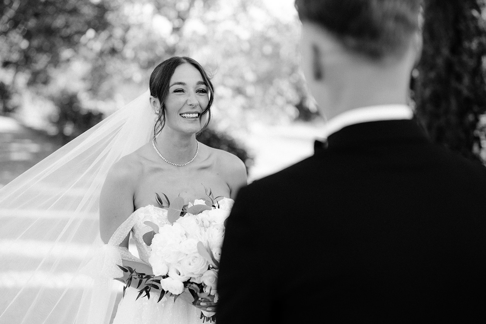 the bride smiling in front of the groom
