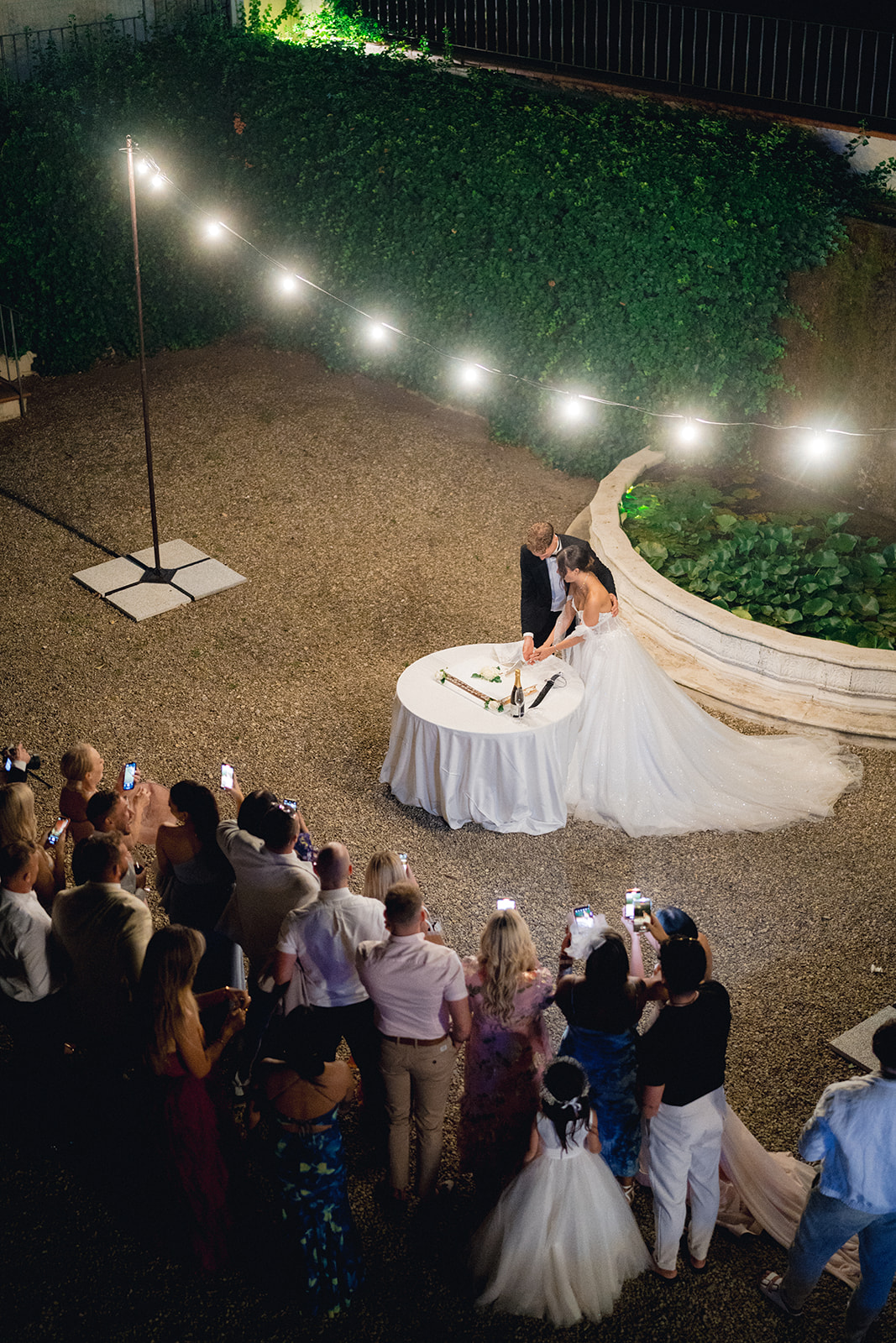 The cutting of the wedding cake by the newlyweds, seen from above