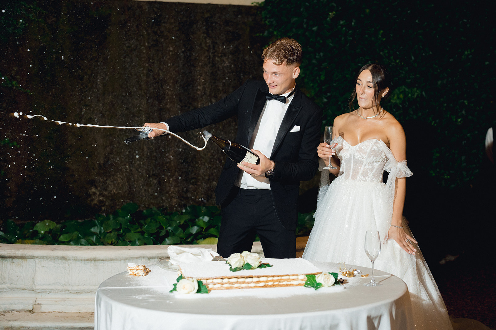 The groom opens the champagne bottle with a saber