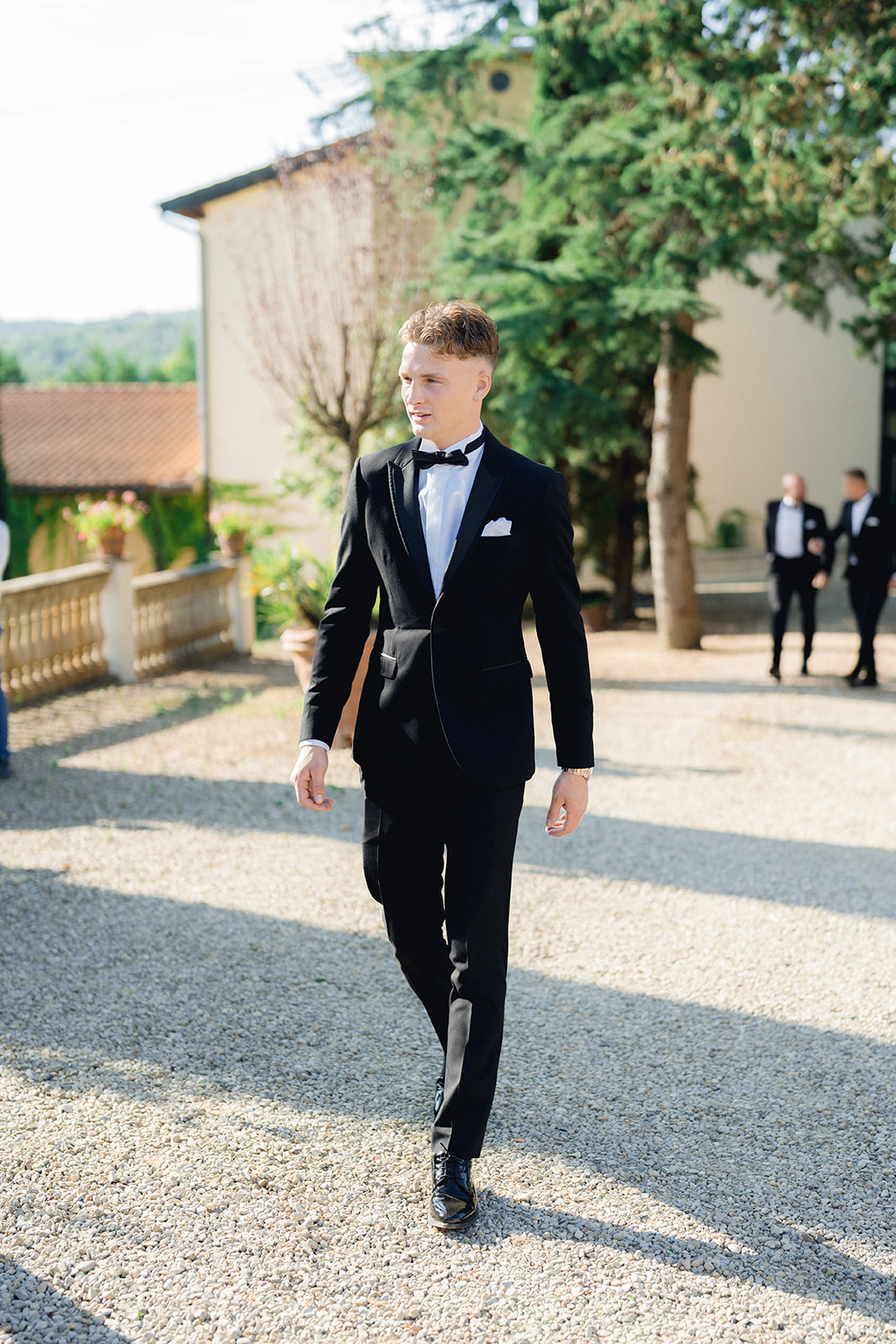 the groom is walking toward the ceremony