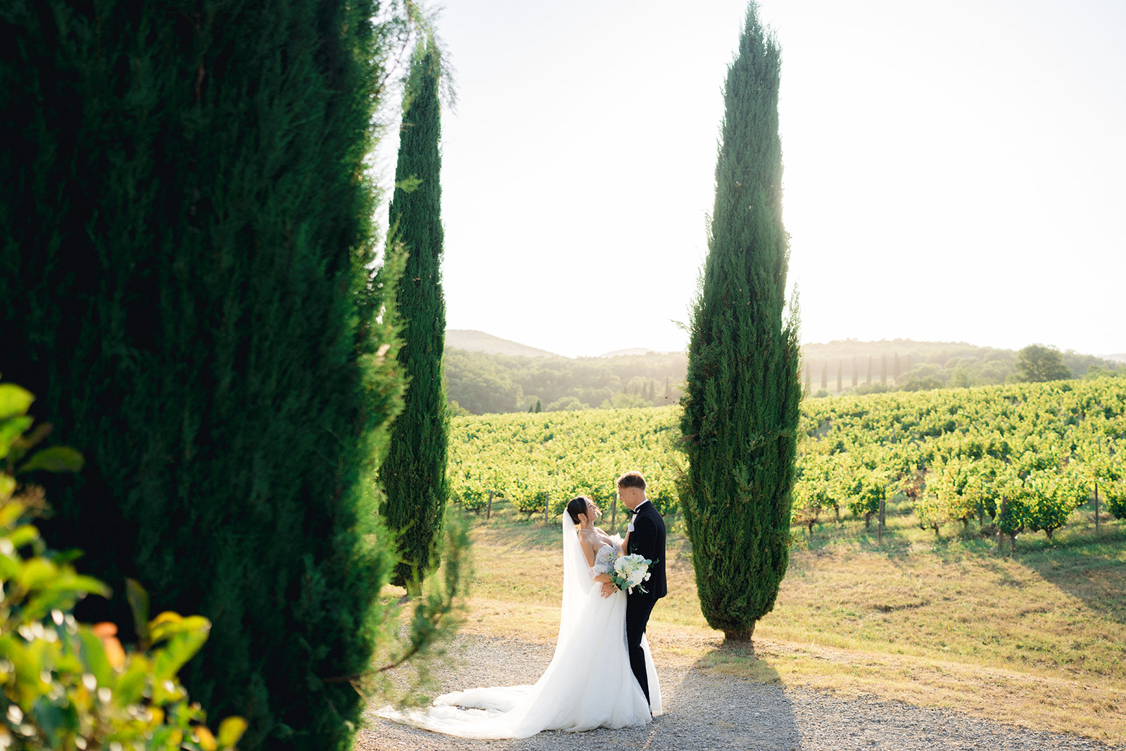The newlyweds posing for photographs surrounded by the classic Tuscan landscape