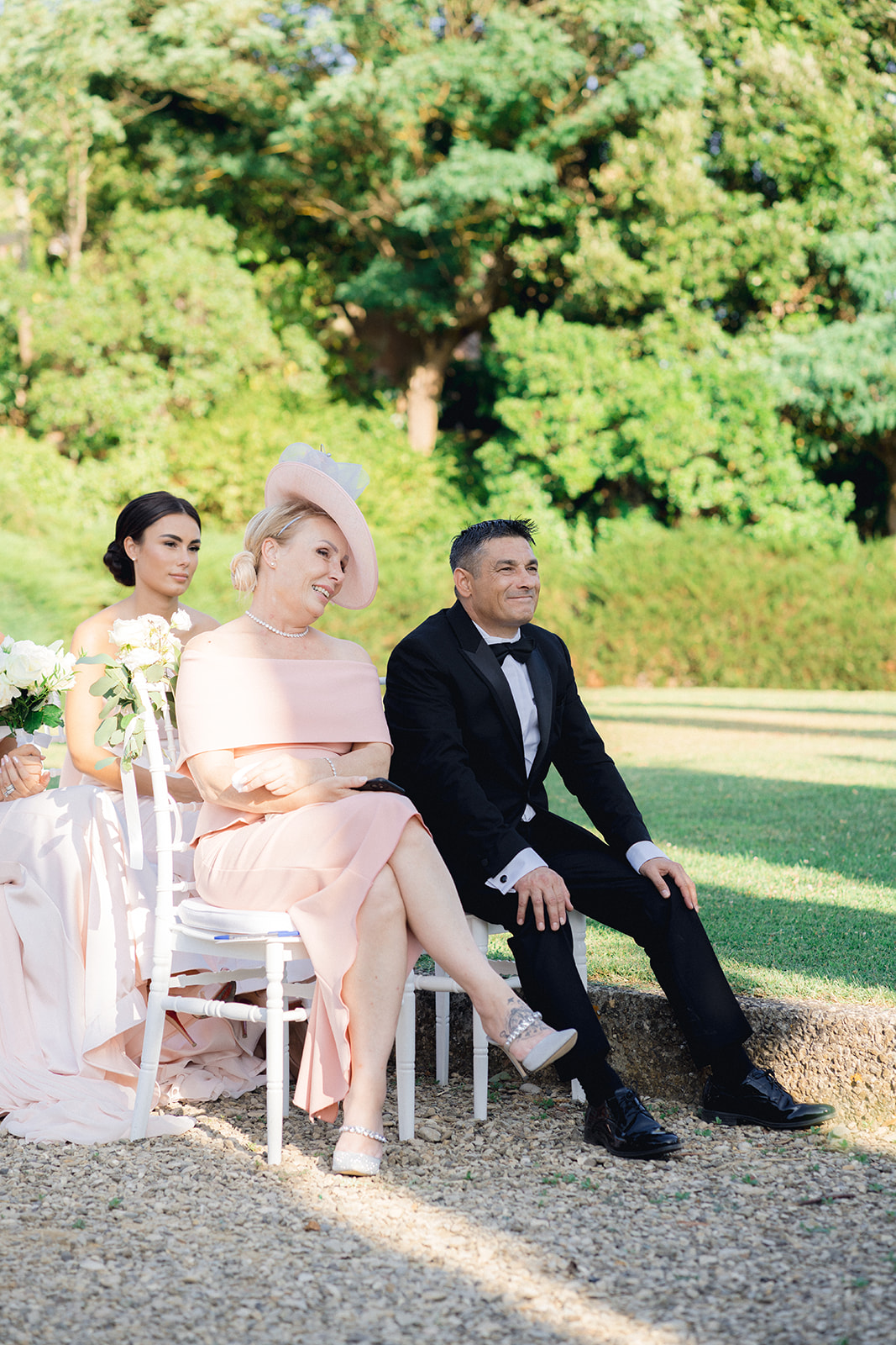the parents of the bride sitting at the ceremony of their daughter