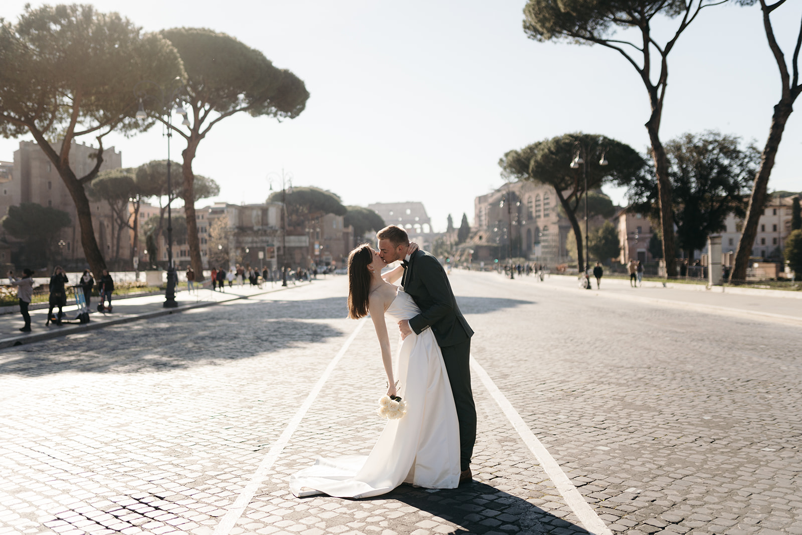 After wedding photoshoot in Rome. Couple walking via dei fori imperiali photographed by Clara Buchberger.