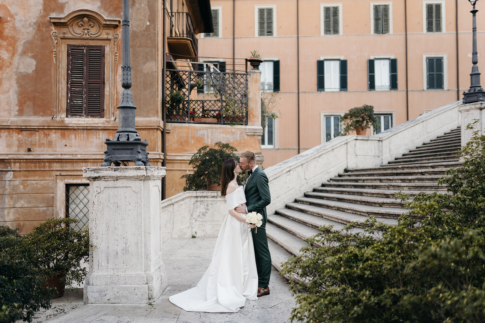 After wedding photoshoot in Rome. Wedding couple standing on the Spanish steps photographed by Clara Buchberger