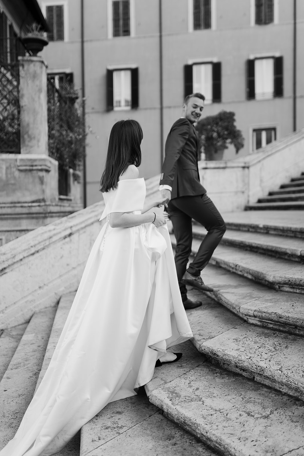 After wedding photoshoot in Rome. Wedding couple walking up the Spanish steps photographed by Clara Buchberger