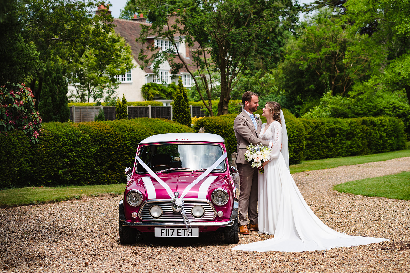 bride and groom stood with their mini cooper car