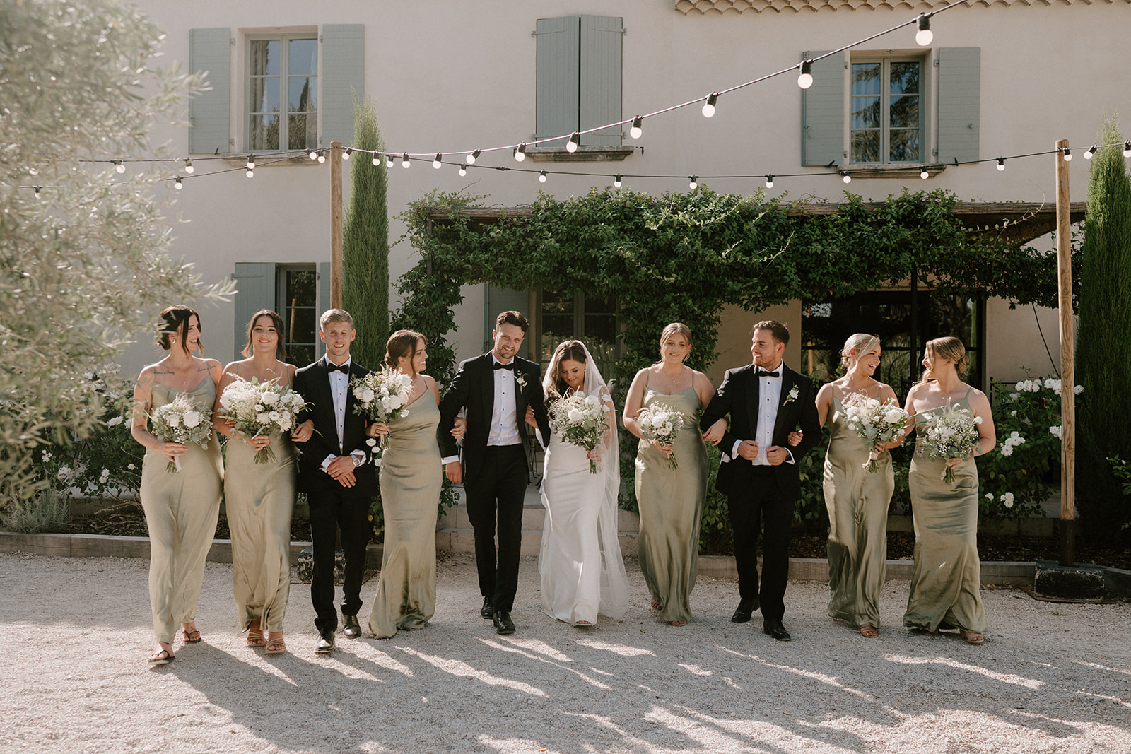 bridal party in neutral colour scheme walking at Le Mas Des Costes in provence