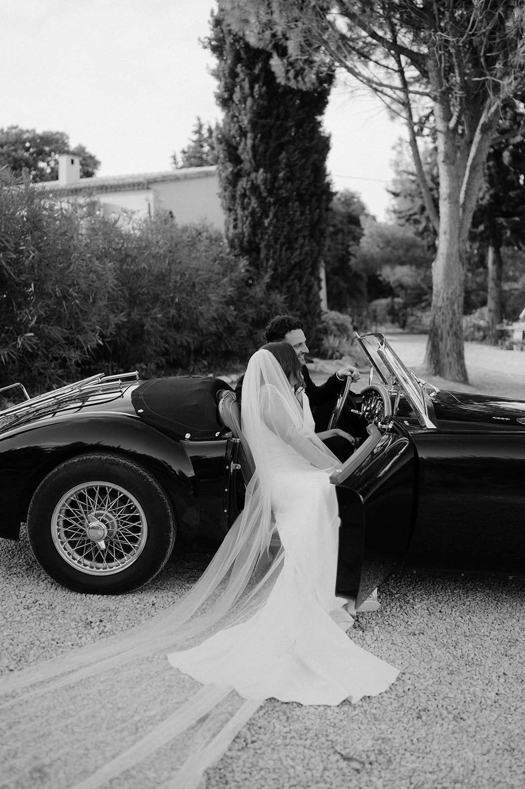 bride and groom sitting in vintage mg classic car at Le Mas Des Costes in provence 